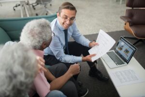 man sitting with couple on a couch discussing investment options
